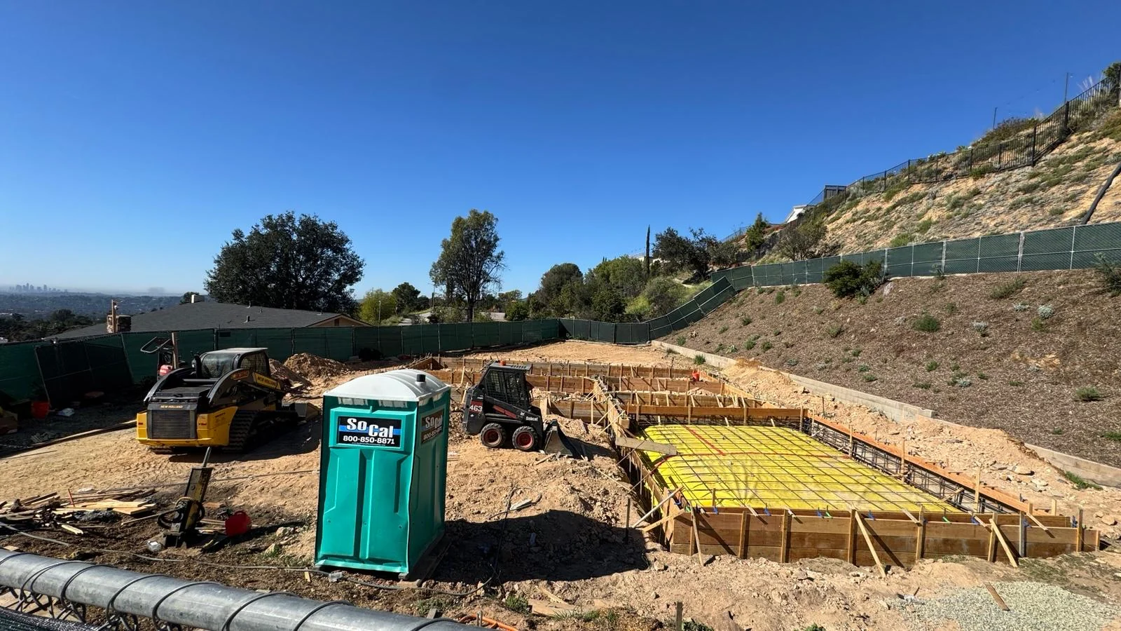 Hillside custom home site during foundation preparation